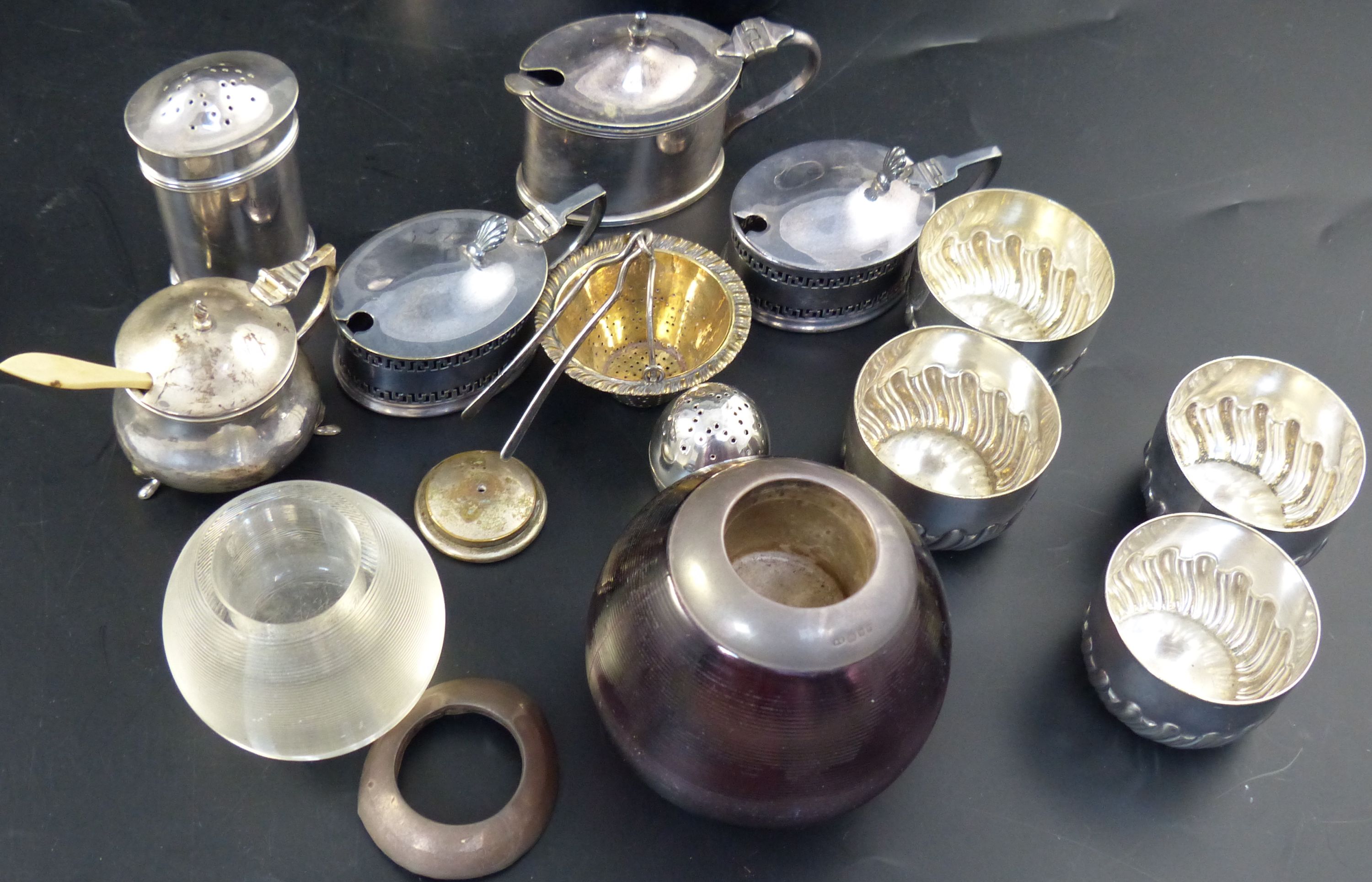 A group of assorted plated condiments, two silver condiments, a silver strainer two match tidies, etc.